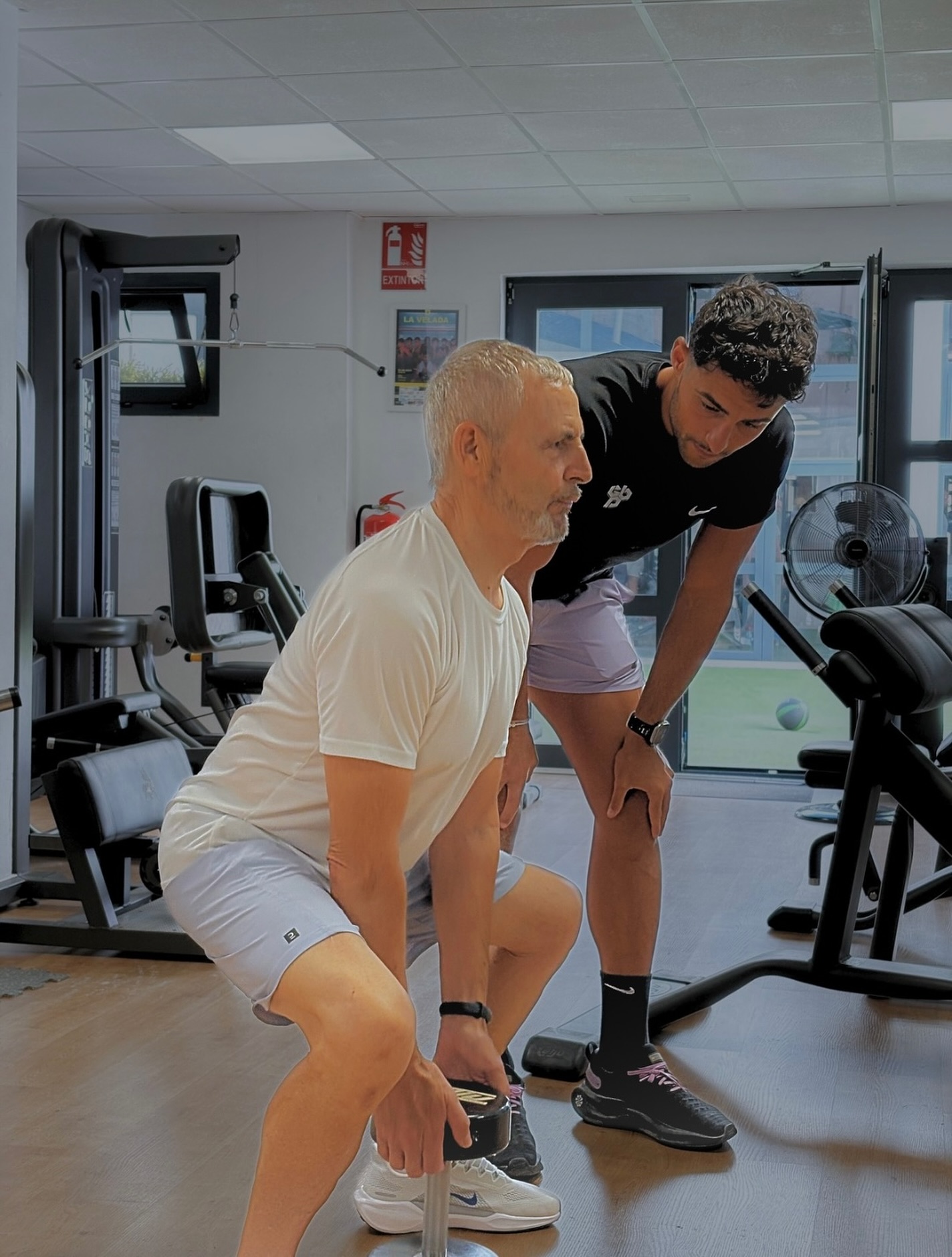 Entrenador guiando a una deportista durante su sesión